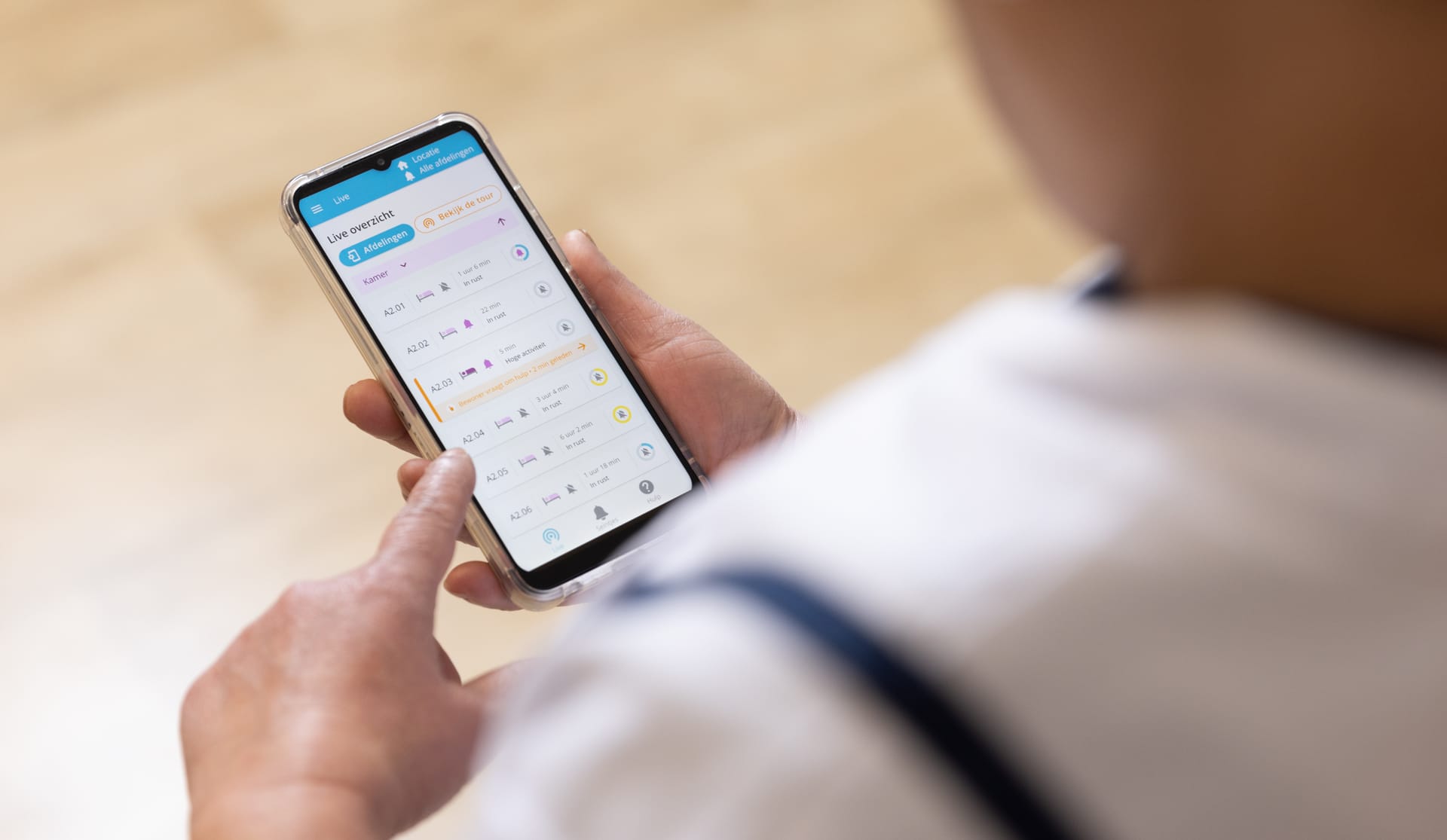 Een zorgmedewerker bekijkt het live overzicht in de Momo app