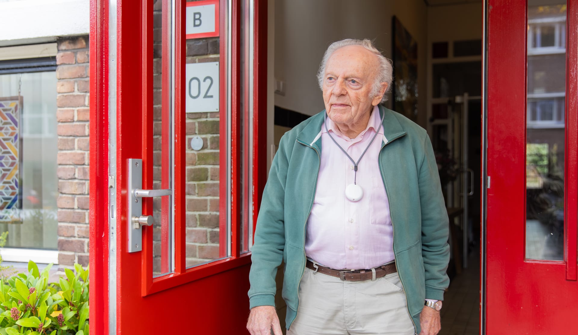 Een bewoner staat in de deuropening met de Momo hanger om